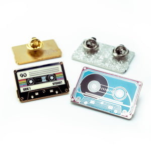 Two cassette tape-themed pins on a white background