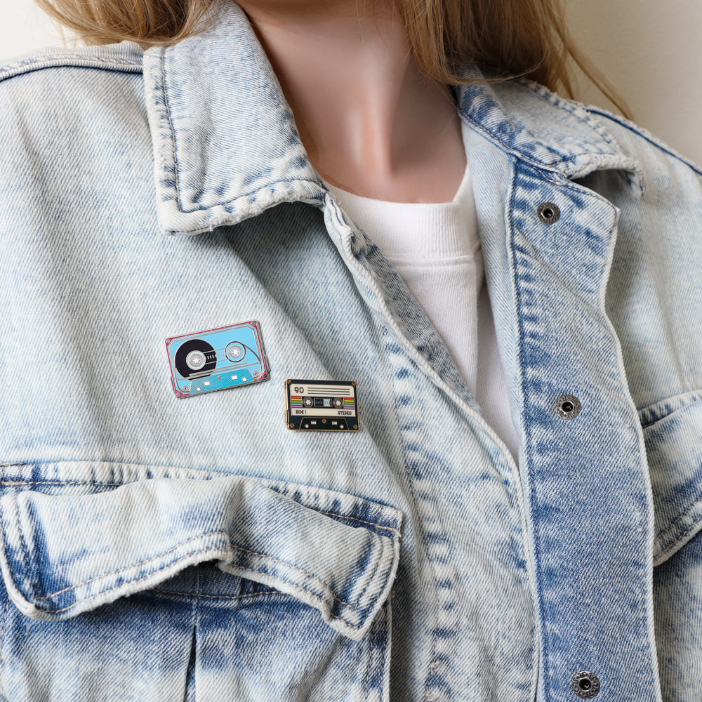 Denim jacket with a cassette tape pin duo on a female model
