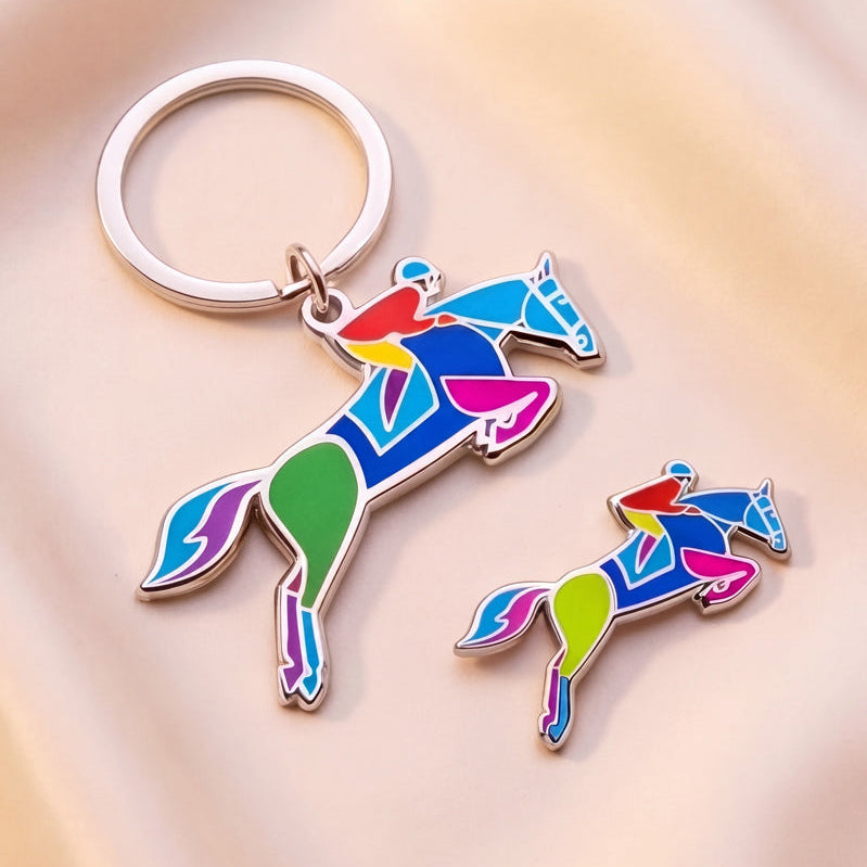 Colorful horse-shaped enamel keychain and pin on a soft beige background by Spot Studio Art.