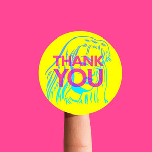 Hand holding a yellow sticker with 'THANK YOU' on a pink background