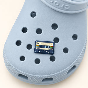 Overhead view of the retro cassette tape charm on a powder-blue Croc.