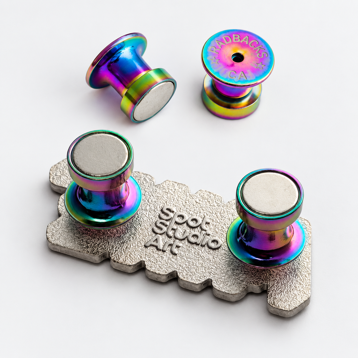 Rainbow Radbacks magnetic pin backs shown loose and attached to a Spot Studio Art enamel pin.