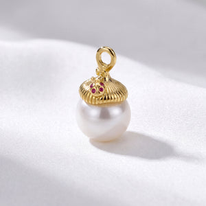 Gold pendant with a acorn design and red gemstones on a white pearl against a light gray background