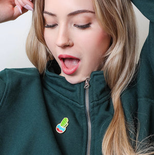 Person wearing a green jacket with a Cactus Enamel Pin from Spot Studio.