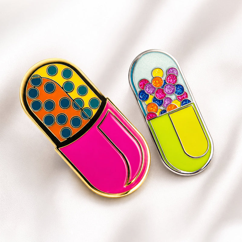 Two colorful pill-shaped pins on a light background