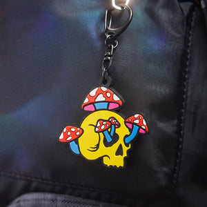 Colorful skull and mushroom keychain attached to a black backpack