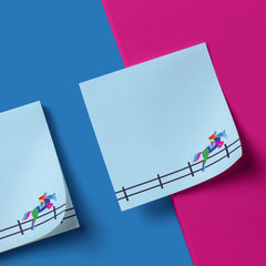 Two blue notepads with colorful equestrian designs on a pink and blue background