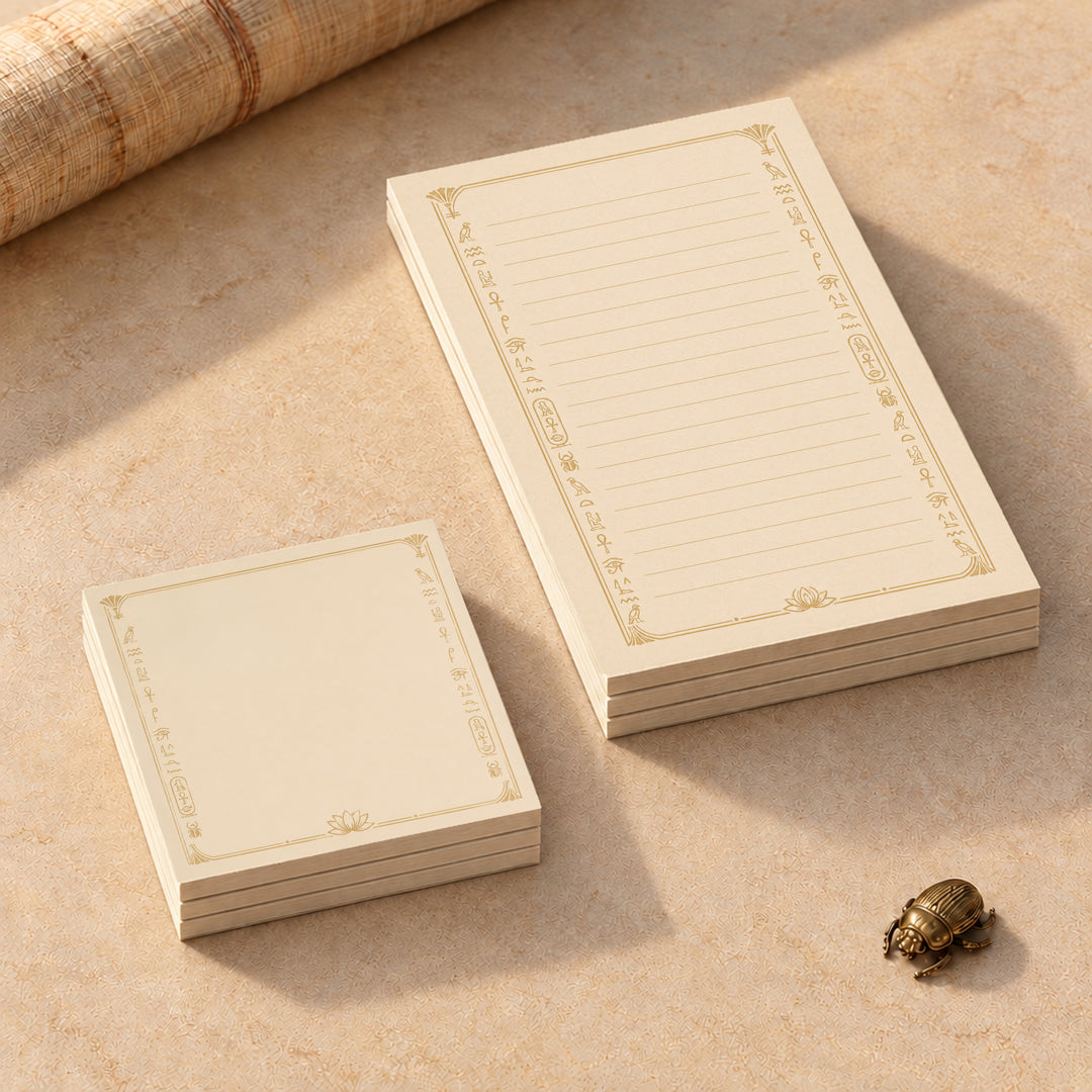 Egyptian lined notepads and square Post-it note pads styled on a warm cream desk with gold hieroglyph-inspired borders