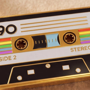 Close-up of a retro-style cassette tape with rainbow colors on a beige background