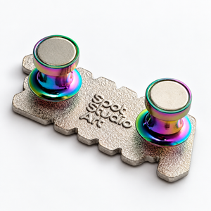 Close-up of two rainbow Radbacks attached to the silver back of a Spot Studio Art enamel pin.